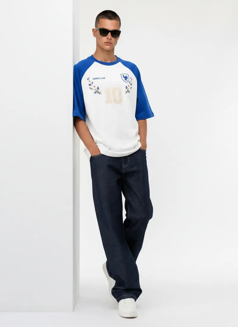 Bully Essence Club Raglan in white / royal on the same male model in black sunglasses in a white studio, posed differently from the other colourways