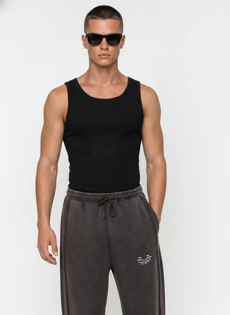 Bully Bully Sweatpant in charcoal on the same male model in black sunglasses in a white studio, posed differently from the other colourways