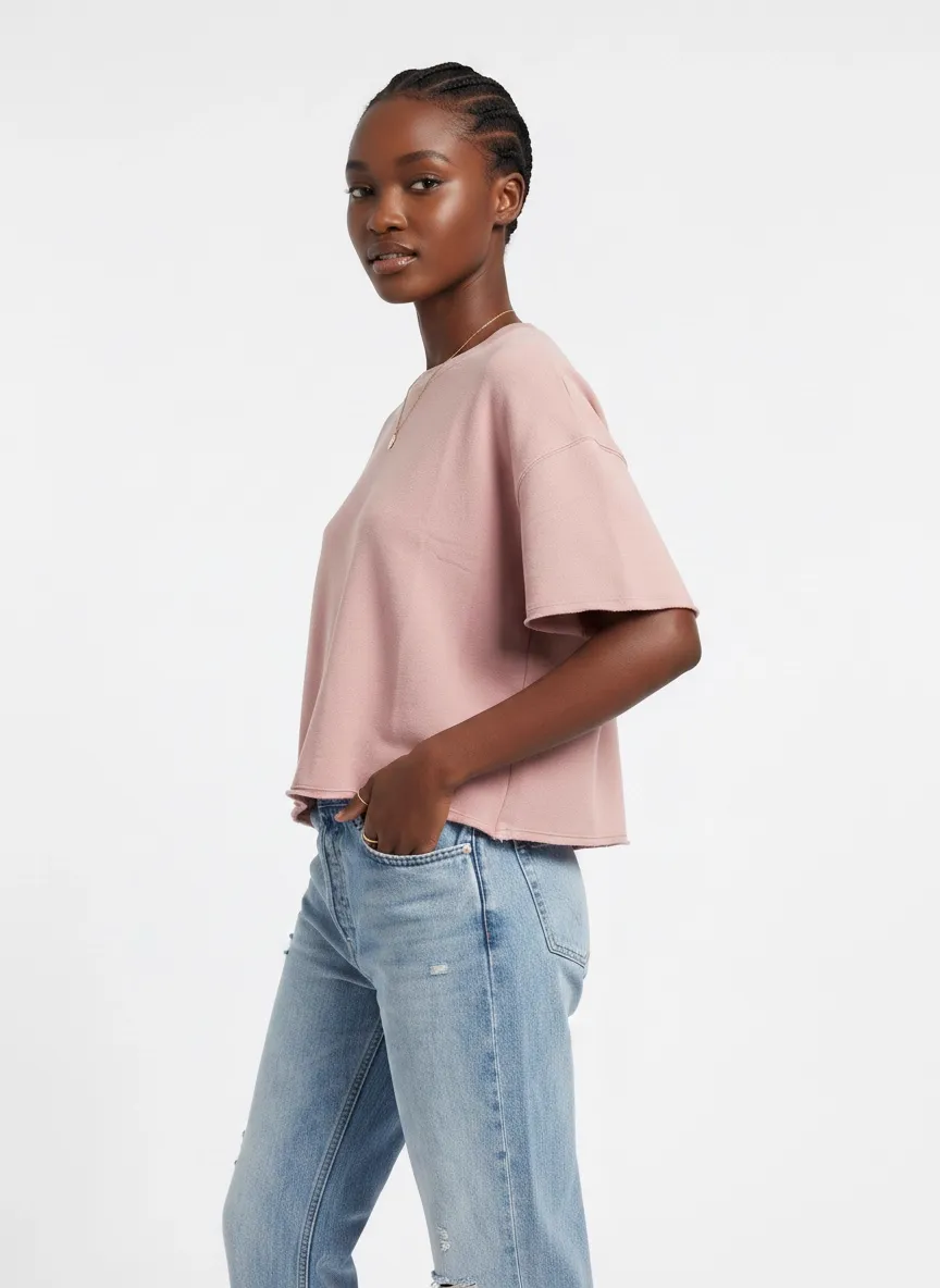 MODA AI catalog output — Black model in pink boxy tee and mom jeans, three-quarter view with hand in pocket showing the tee's oversized fit