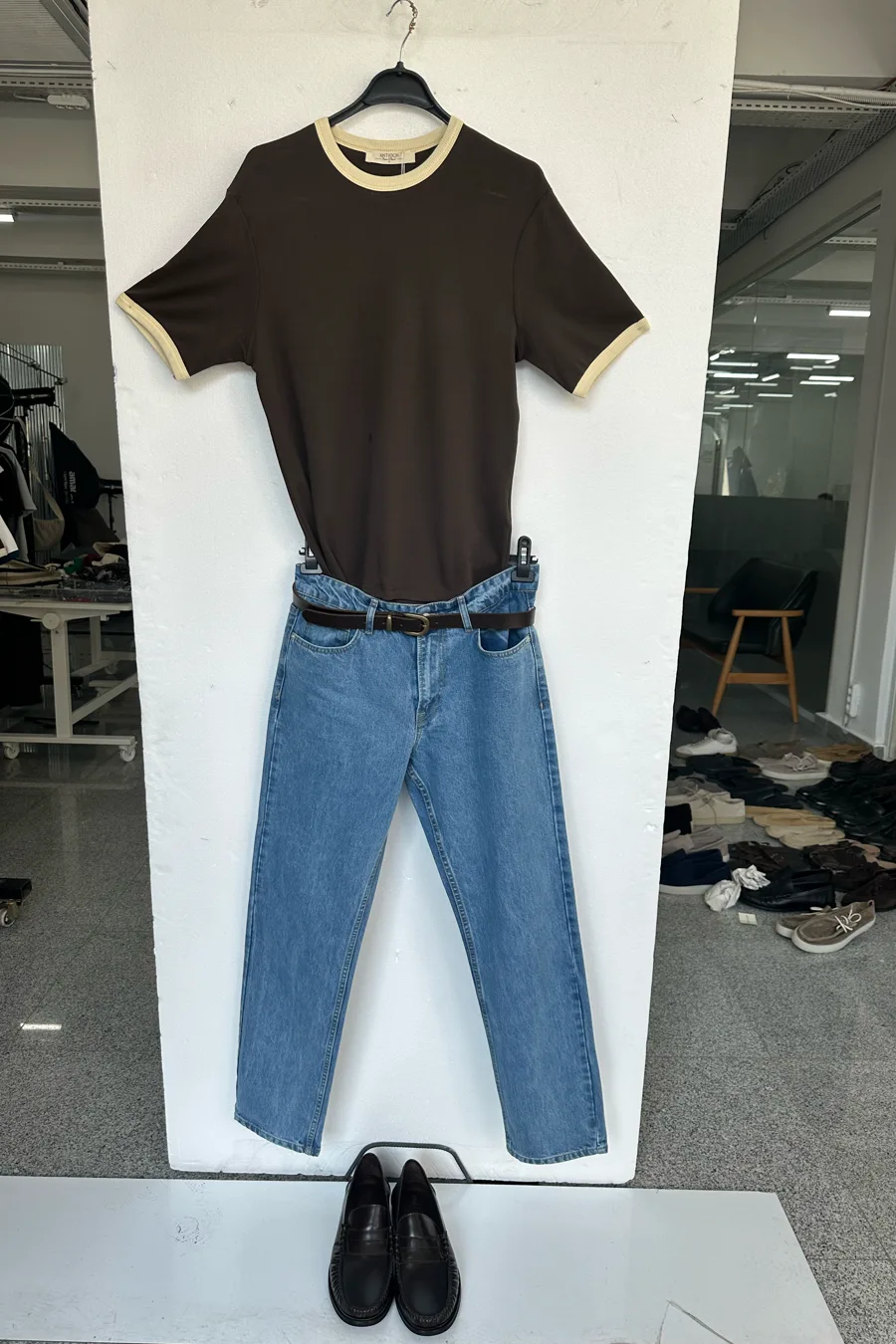 Input flat lay — a brown ringer tee laid over blue jeans with a belt across the waist and brown shoes