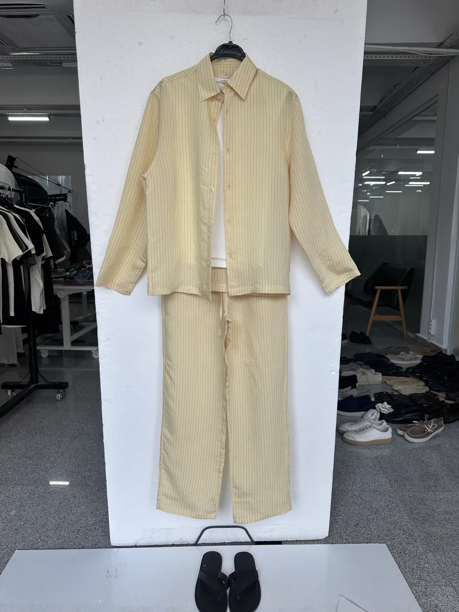 Input flat lay — a pale-yellow overshirt and matching trousers laid together on a surface