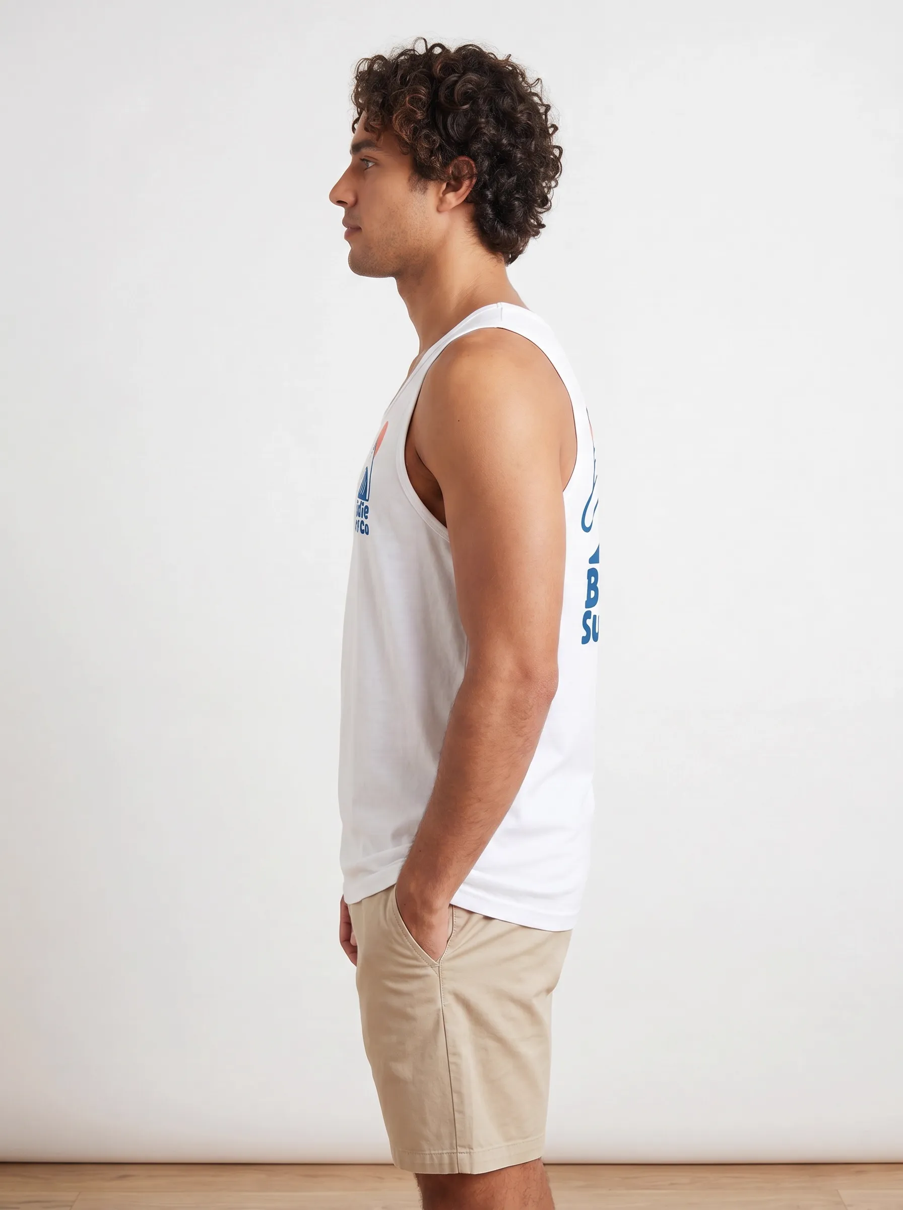 MODA AI side profile — curly-haired model in white Bödie Surf Co tank top, full side view showing the small chest logo through the armhole and the large back logo simultaneously, both rendered in matching blue and orange