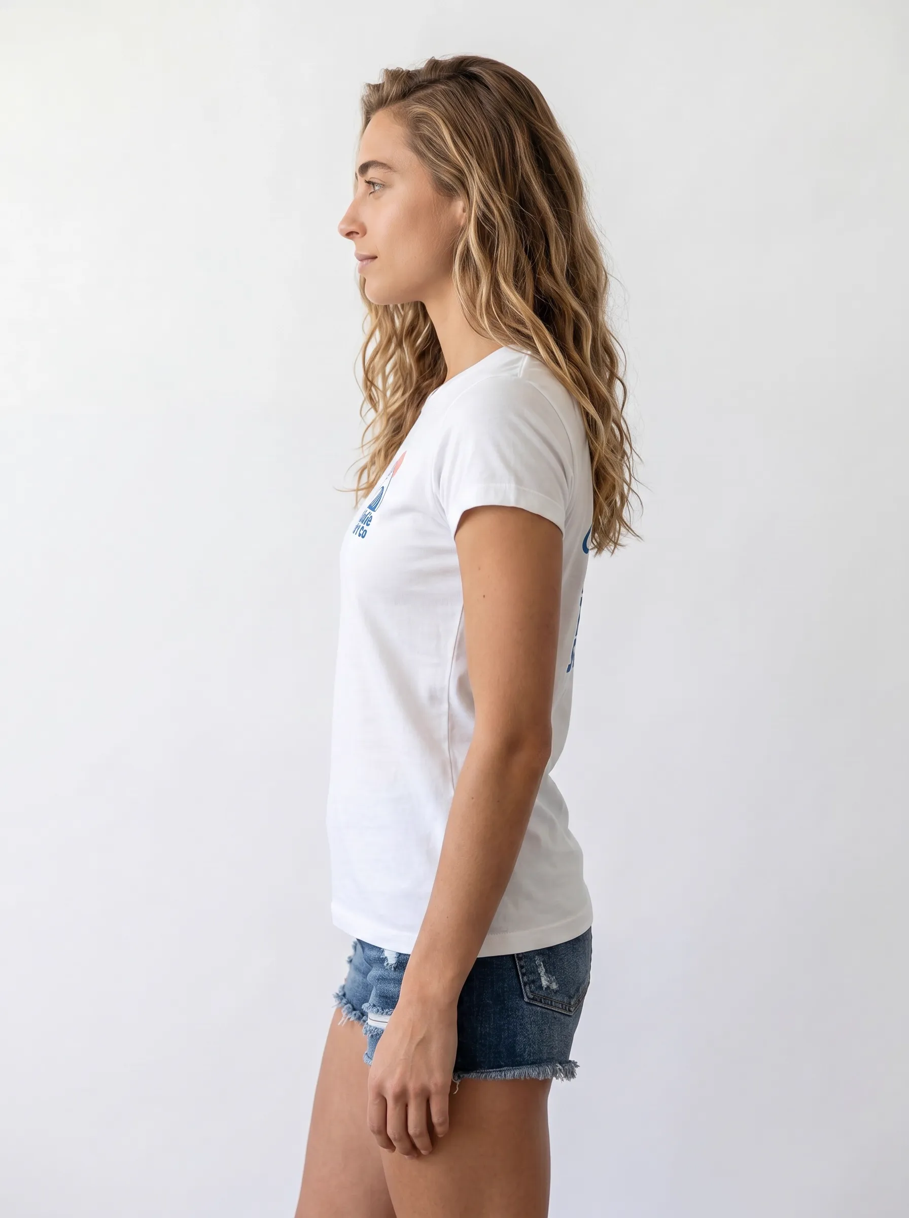 MODA AI side profile — long-haired model in white Bödie Surf Co tee, full side view showing the chest wave logo and the matching back logo through the same shoulder line, both rendered in matching blue tones