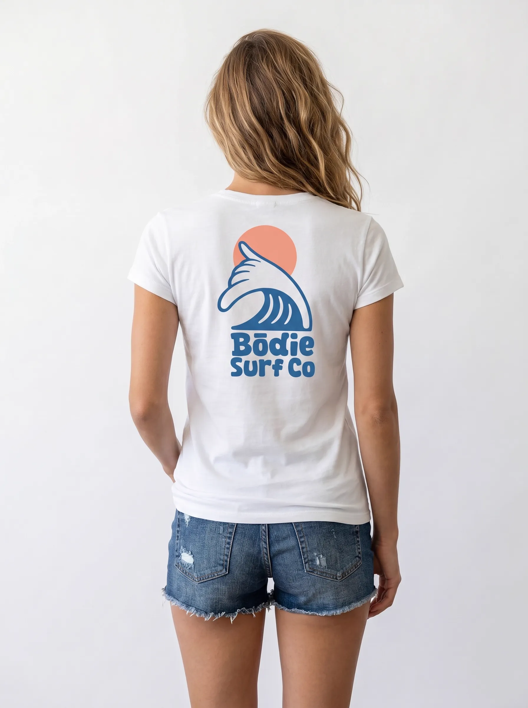MODA AI output 4 — brunette female model in white Bödie Surf Co tee, locked by face reference, chest wave logo consistent across catalog angle