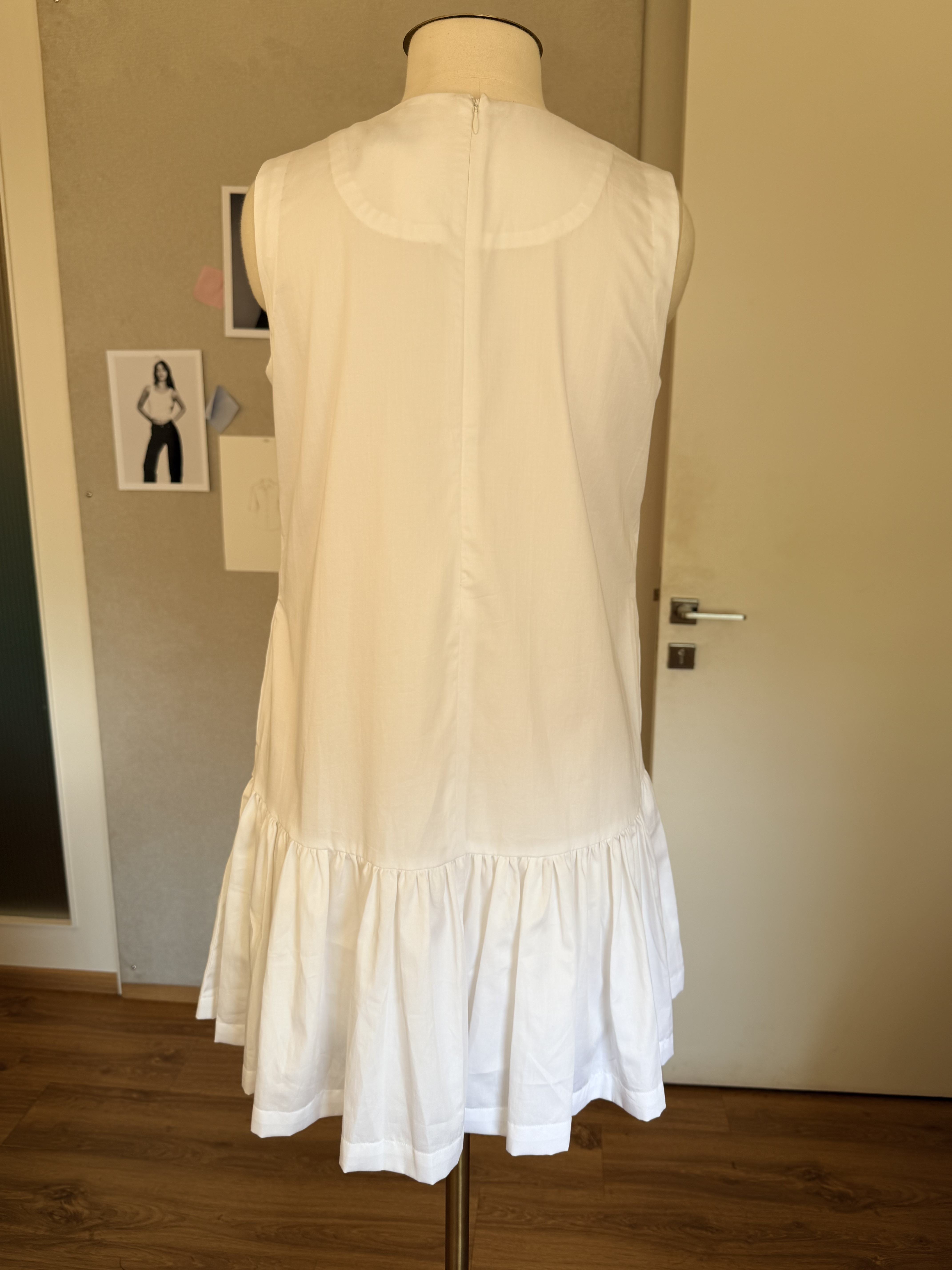 White dress on mannequin — back view showing zipper