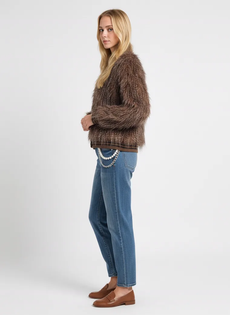 A shaggy brown faux-fur jacket with long brown and cream pile and a button front, worn with straight blue jeans and brown loafers. Shaggy Faux-Fur Jacket in brown, three-quarter view
