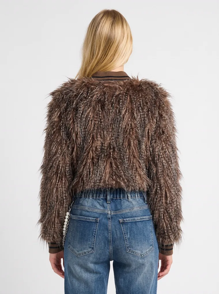 A shaggy brown faux-fur jacket with long brown and cream pile and a button front, worn with straight blue jeans and brown loafers. Shaggy Faux-Fur Jacket in brown, back view, close