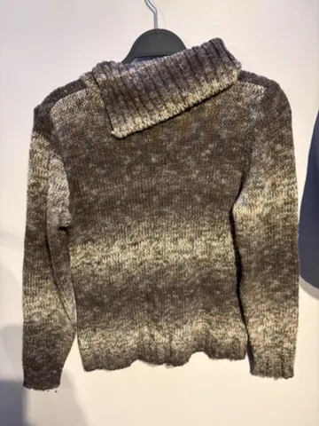 The seller’s phone photo of the marled knit on a hanger, back view