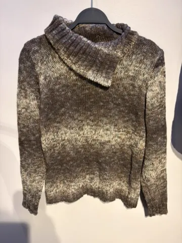 The seller’s phone photo of a marled brown funnel-neck knit on a hanger, front view