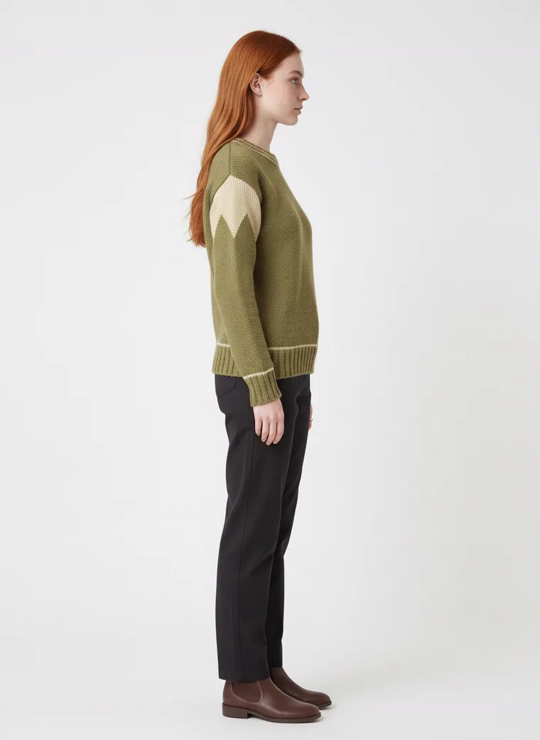 An olive crew-neck knit with tan contrast shoulder panels and cream tipping at the neck and cuffs, worn with black trousers. Knit with Contrast Panels in olive, side view